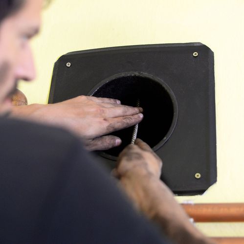 A couple warming their feet in front of a stove fire