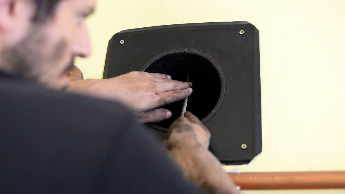 a chimney sweep cleaning the in side of a vent